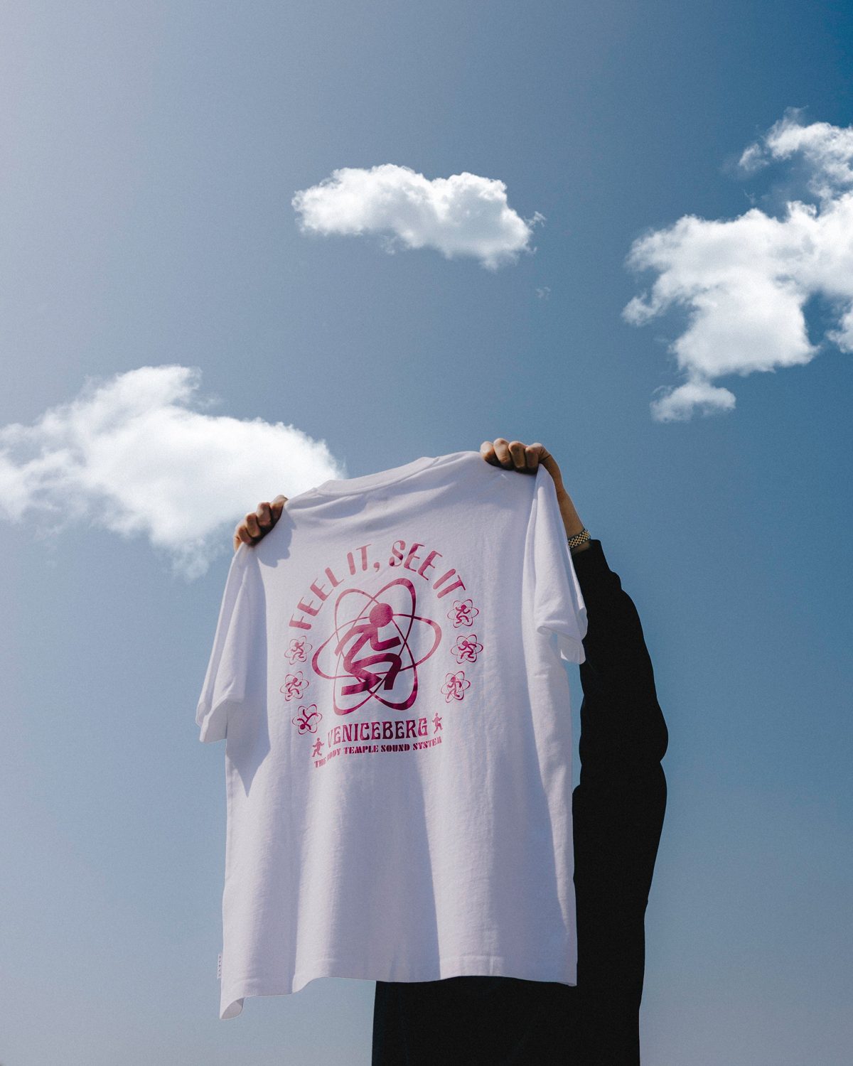 Cenário D externa: camiseta segurada contra céu com nuvens